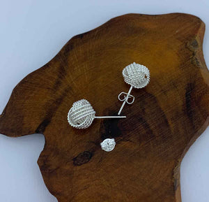 silver knot stud earrings on wood