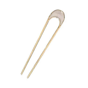 A pair of gold-colored hair forks with white enamel tops, designed with a slight curve and pronged ends.