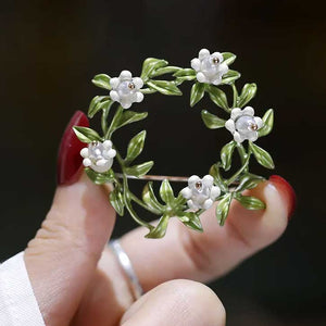 flower wreath brooch fingers