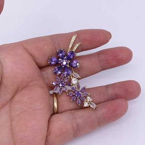 purple flowe brooch on hand