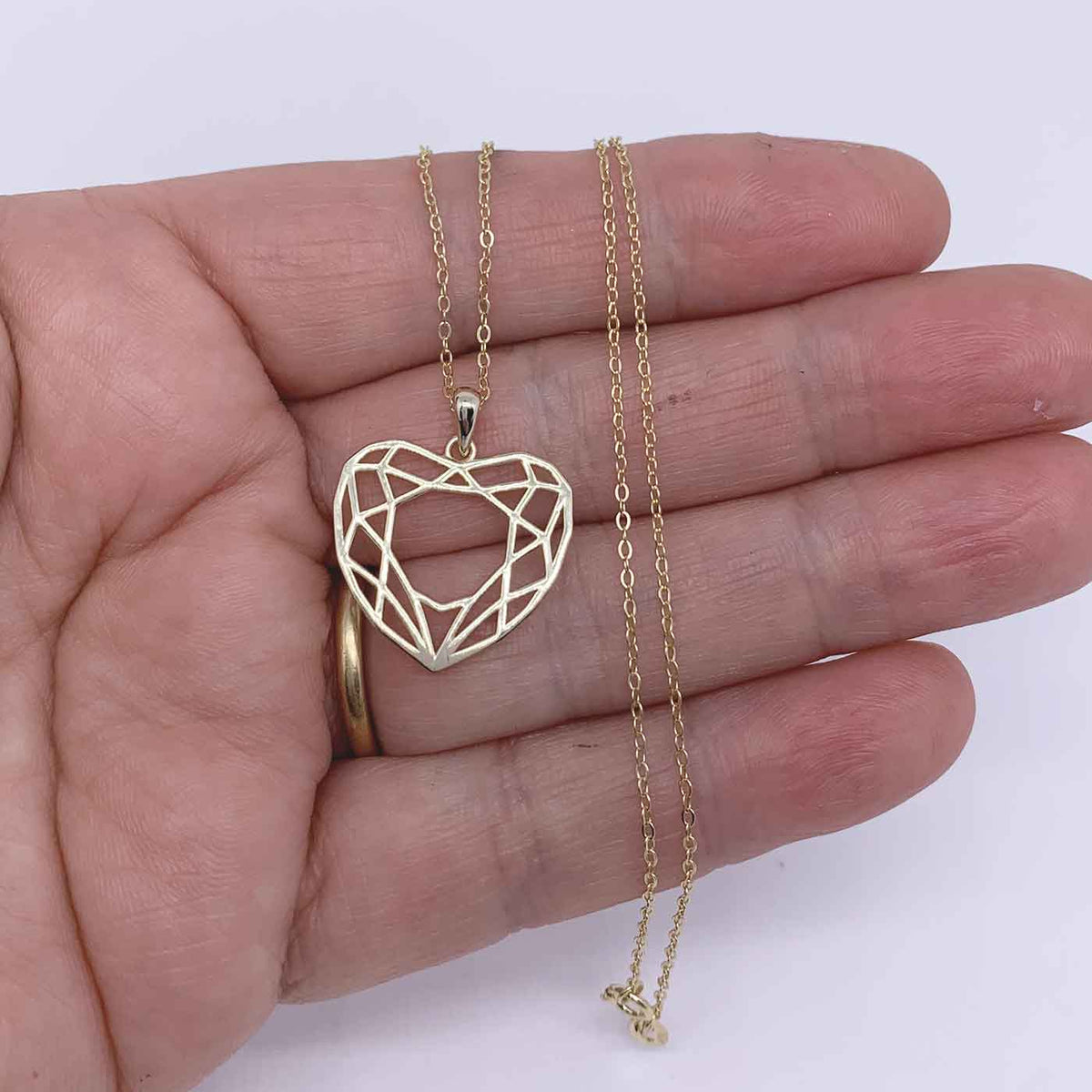 gold heart necklace hand