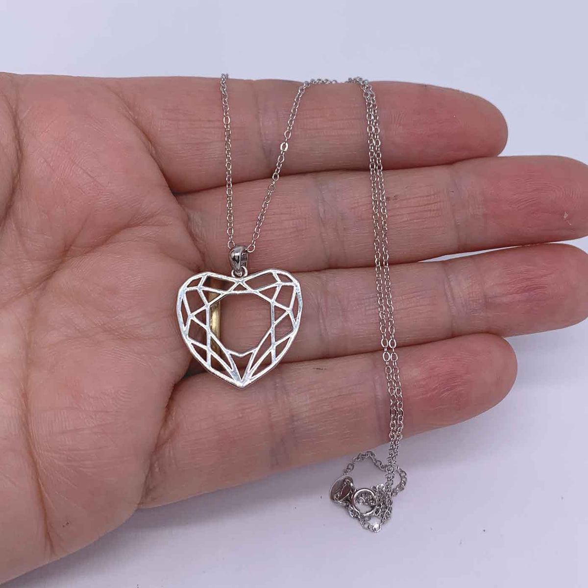 silver heart necklace hand