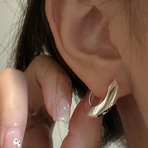 silver huggie earrings for women worn on ear