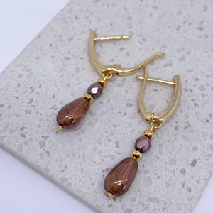 gold huggie earrings jewellery on stone