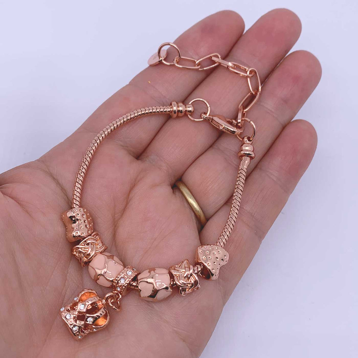 rose gold charm bracelet crown on hand