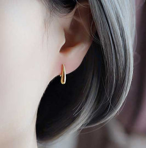 gold teardrop earrings on ear