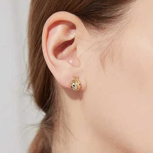 Gold Ladybug Earrings on ear