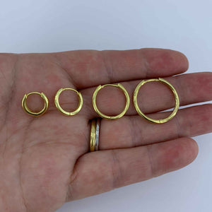 gold hoop earrings on hand